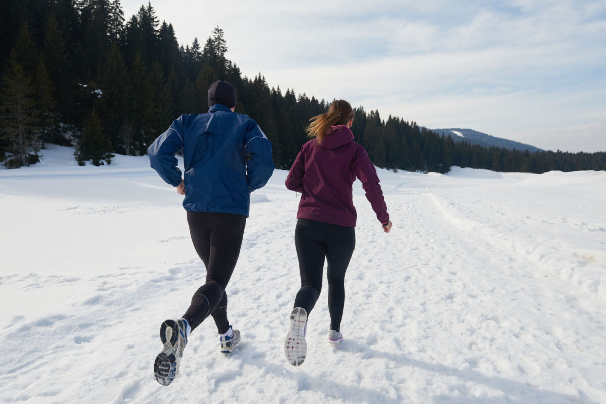 Healthy Young Couple Jogging Outside On Snow In Forest Athlete Running On Beautiful Sunny Winter Day